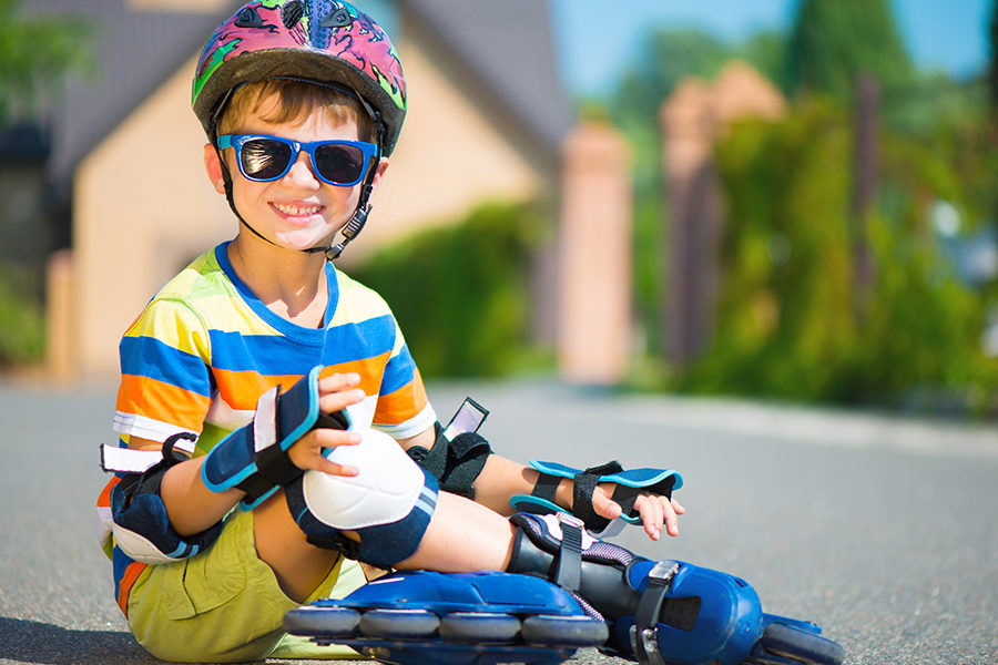 Cute little boy in helmet posing with rollers